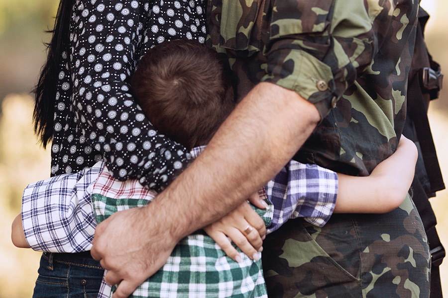 soldier and family hugging