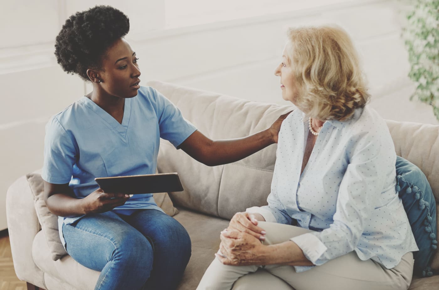 Caregiver showing patient information on an iPad.